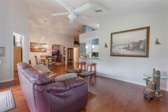 living room featuring ceiling fan, wood-type flooring, sink, and high vaulted ceiling