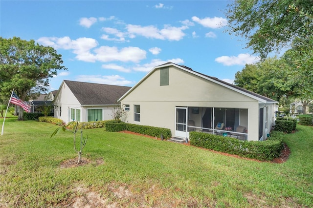 back of house featuring a sunroom and a yard