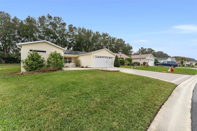 ranch-style home with solar panels, a garage, and a front lawn