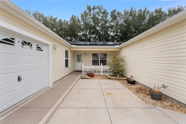 entrance to property featuring solar panels and a patio area