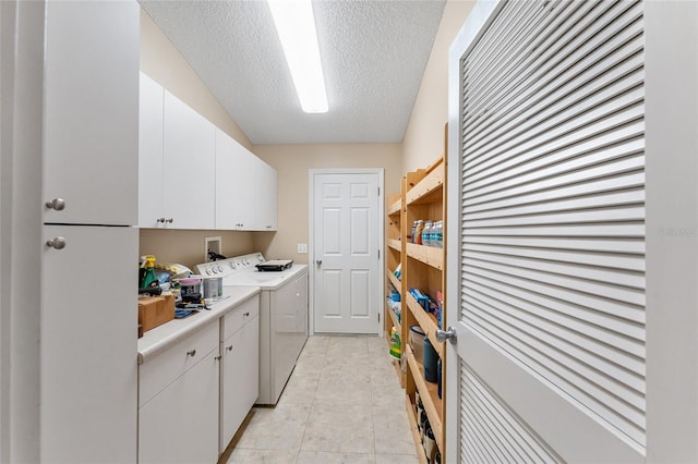 washroom with washer and clothes dryer, light tile patterned floors, cabinets, and a textured ceiling