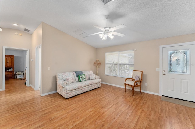 sitting room featuring ceiling fan, vaulted ceiling, a textured ceiling, and light hardwood / wood-style flooring