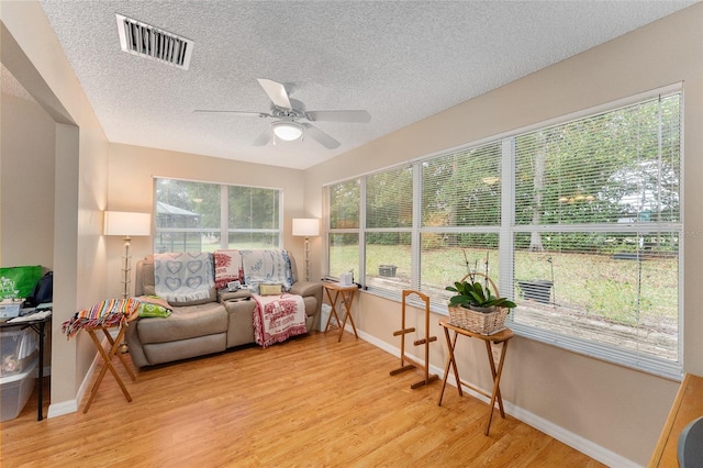 sunroom / solarium featuring ceiling fan