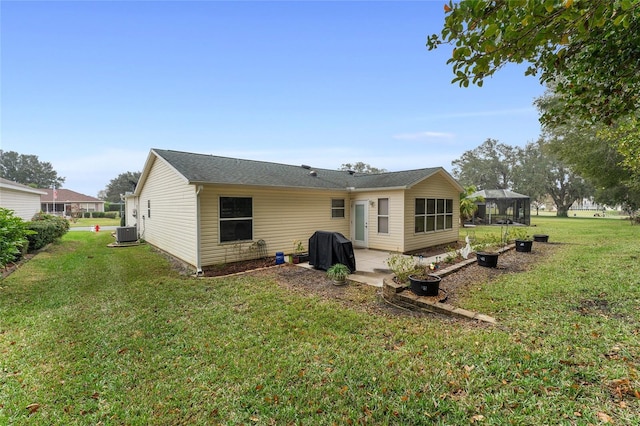 rear view of house featuring cooling unit, a yard, and a patio