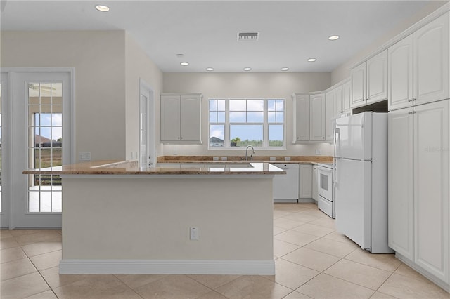 kitchen featuring white cabinets, light tile patterned flooring, and white appliances