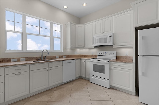 kitchen featuring white cabinetry, sink, light tile patterned floors, and white appliances