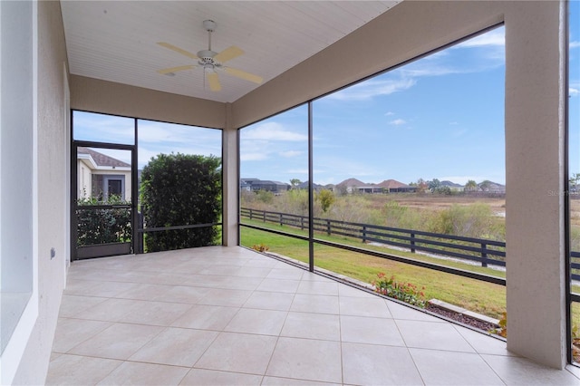 unfurnished sunroom with ceiling fan