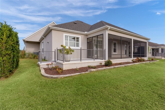 back of property with a sunroom and a yard