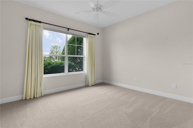 carpeted spare room featuring ceiling fan and a healthy amount of sunlight