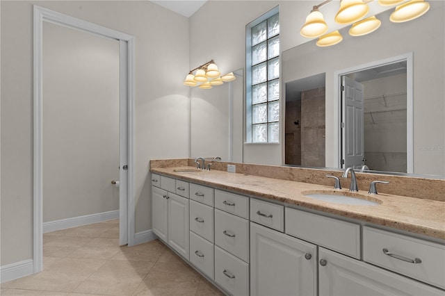 bathroom with tile patterned flooring, vanity, and a tile shower