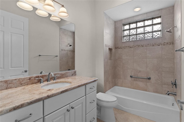 full bathroom featuring tile patterned flooring, vanity, tiled shower / bath combo, and toilet