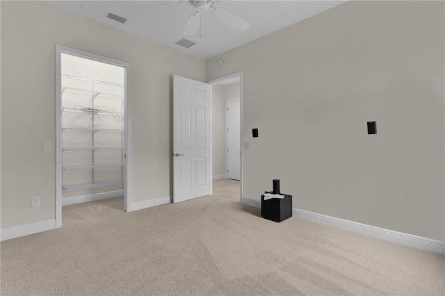 unfurnished bedroom featuring light carpet, a closet, and ceiling fan