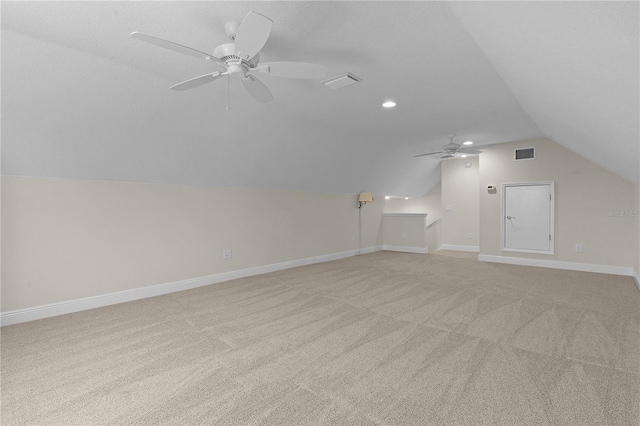 bonus room with ceiling fan, light colored carpet, and a textured ceiling