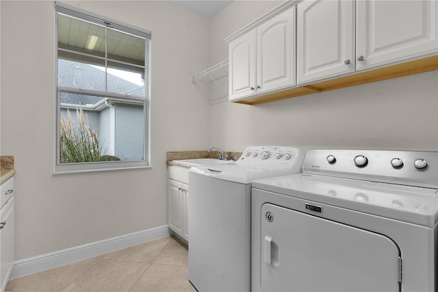 clothes washing area with cabinets, light tile patterned floors, independent washer and dryer, and sink