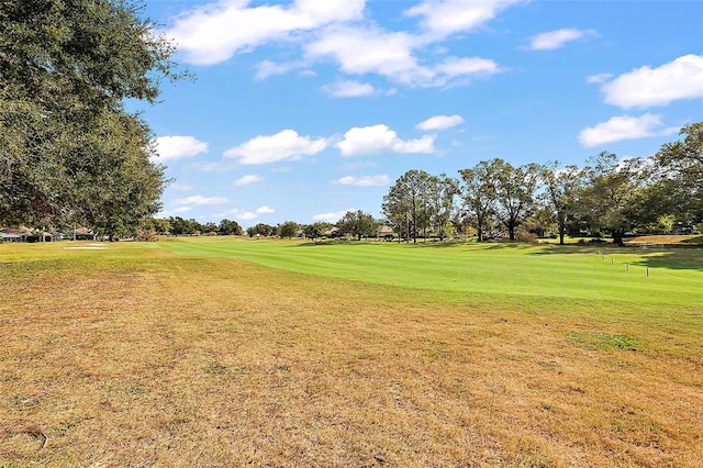 view of home's community with golf course view and a yard