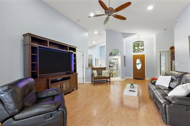 living room with light hardwood / wood-style flooring, high vaulted ceiling, and ceiling fan