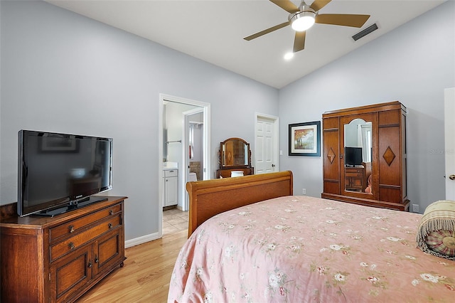 bedroom featuring ensuite bath, ceiling fan, light hardwood / wood-style flooring, and vaulted ceiling