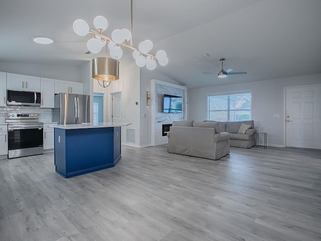 kitchen featuring hanging light fixtures, stainless steel appliances, a kitchen island, light hardwood / wood-style floors, and white cabinets