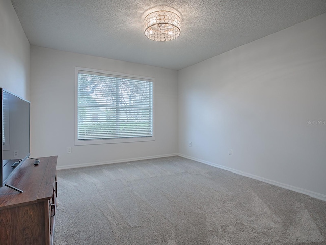 interior space with light colored carpet, a textured ceiling, and an inviting chandelier