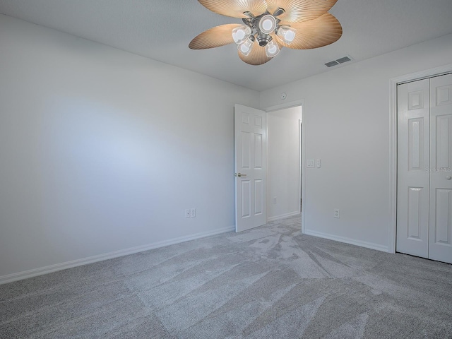 unfurnished bedroom with ceiling fan, light colored carpet, and a closet