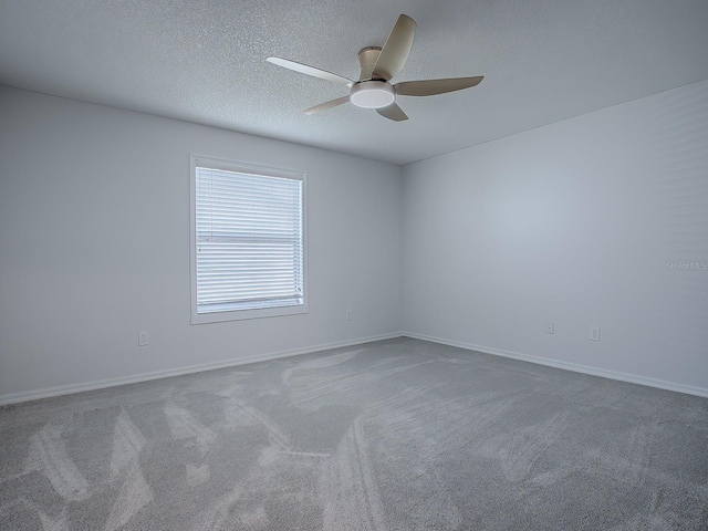 carpeted empty room featuring a textured ceiling and ceiling fan