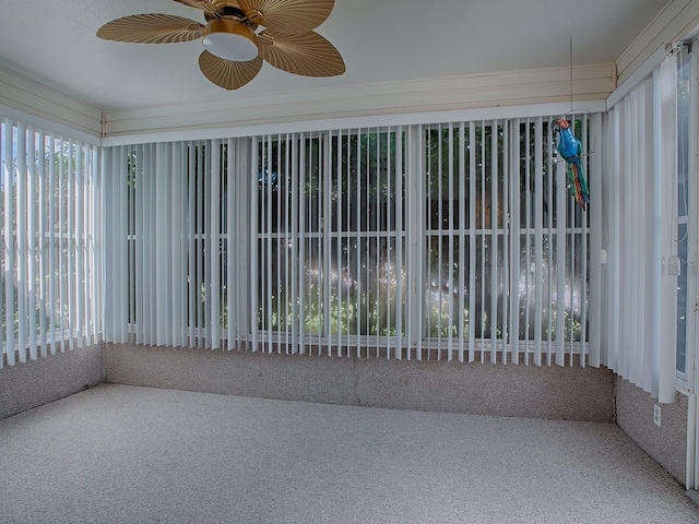 unfurnished sunroom featuring ceiling fan