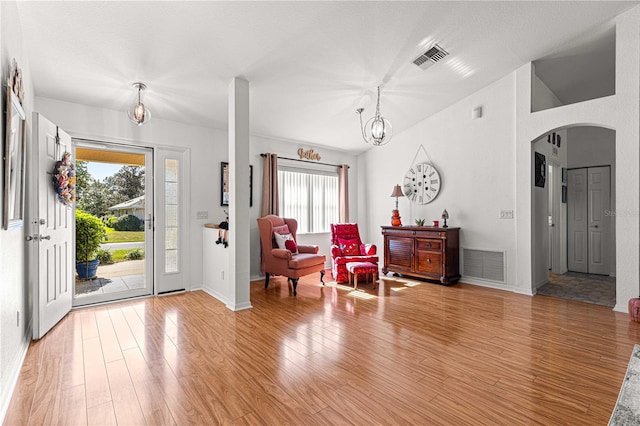 foyer with wood-type flooring and a notable chandelier