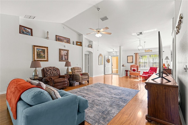 living room with ceiling fan with notable chandelier, light wood-type flooring, and lofted ceiling