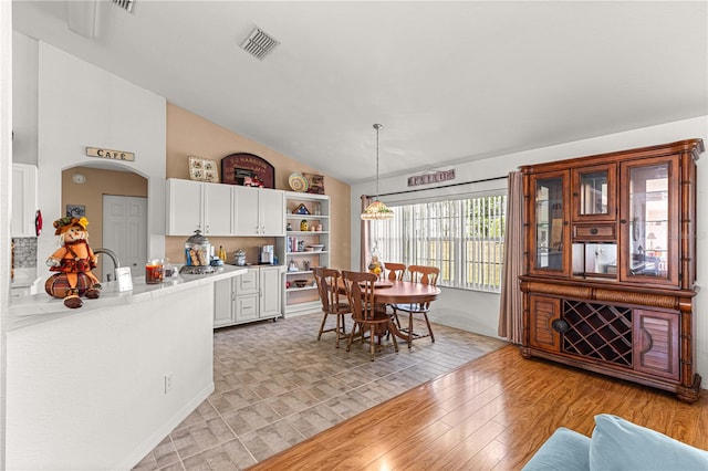 dining space featuring vaulted ceiling and light wood-type flooring