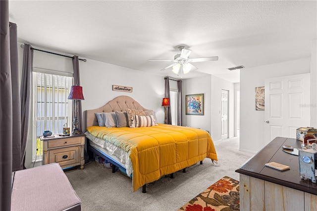 bedroom with carpet flooring, ceiling fan, and a textured ceiling