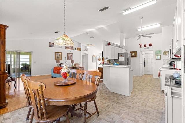 dining area featuring light hardwood / wood-style flooring, high vaulted ceiling, and ceiling fan