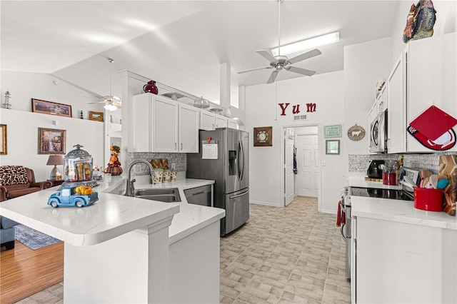 kitchen featuring kitchen peninsula, sink, a kitchen bar, white cabinetry, and stainless steel appliances