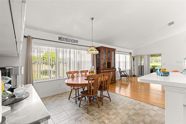 dining room with light hardwood / wood-style floors and lofted ceiling