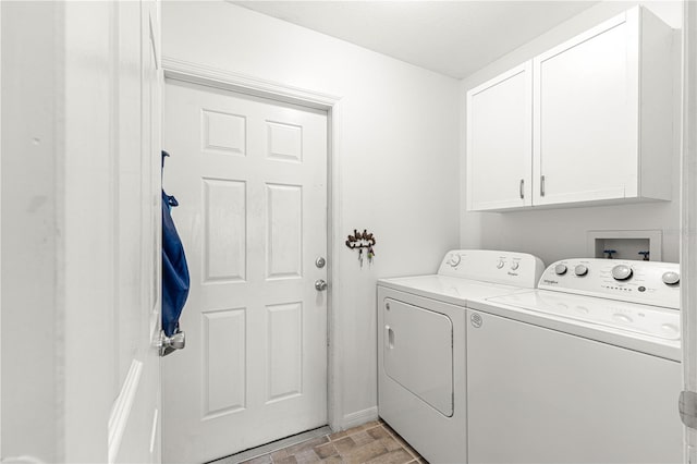 clothes washing area featuring washer and clothes dryer and cabinets