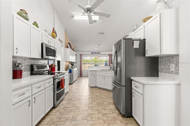 kitchen featuring white cabinets, ceiling fan, appliances with stainless steel finishes, and tasteful backsplash