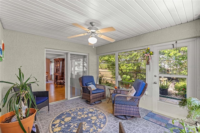 sunroom / solarium with wood ceiling, ceiling fan, and a healthy amount of sunlight