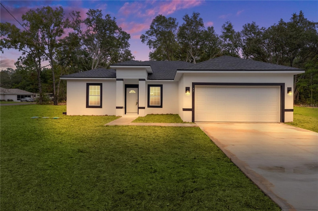 view of front of house with a garage and a yard