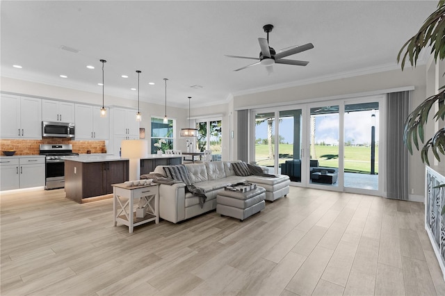 living room featuring light hardwood / wood-style flooring, ceiling fan, and crown molding