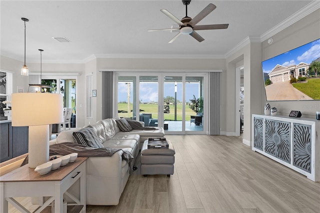 living room featuring light wood-type flooring, a wealth of natural light, and ornamental molding