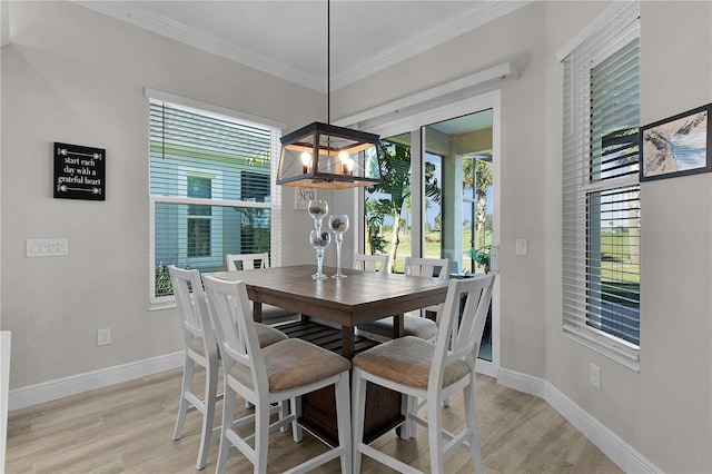 dining area with light wood-type flooring and ornamental molding