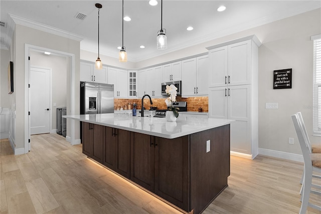 kitchen with a large island, light hardwood / wood-style flooring, white cabinets, and stainless steel appliances