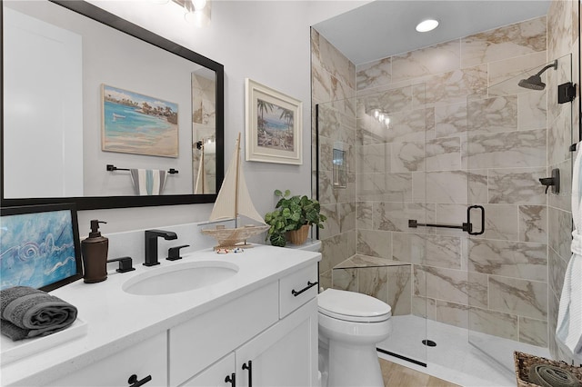 bathroom featuring vanity, toilet, and a shower with door