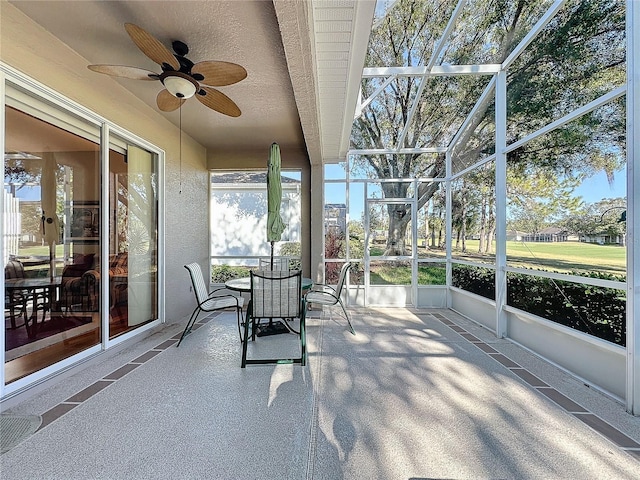 unfurnished sunroom with ceiling fan