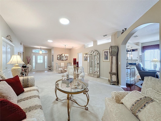 carpeted living room featuring a wealth of natural light and an inviting chandelier