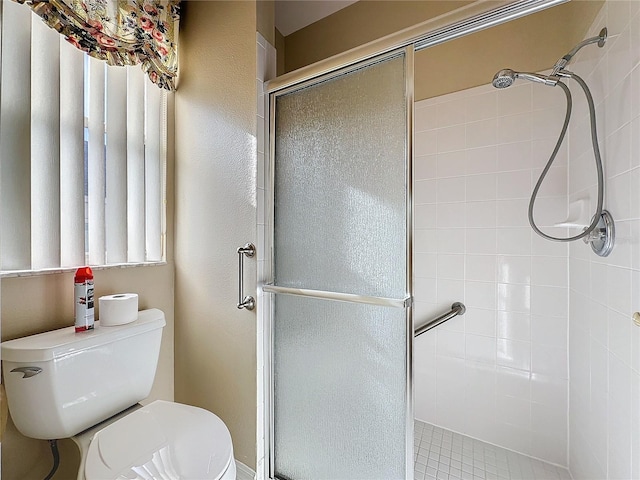 bathroom featuring an enclosed shower and toilet