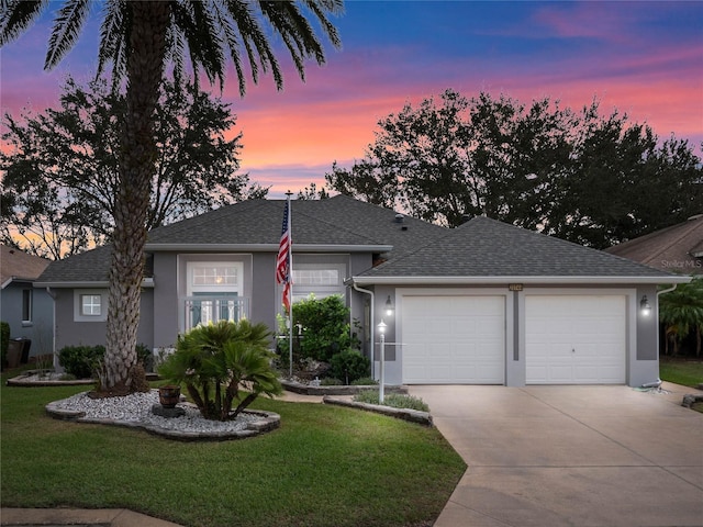 single story home featuring roof with shingles, stucco siding, concrete driveway, a front lawn, and a garage