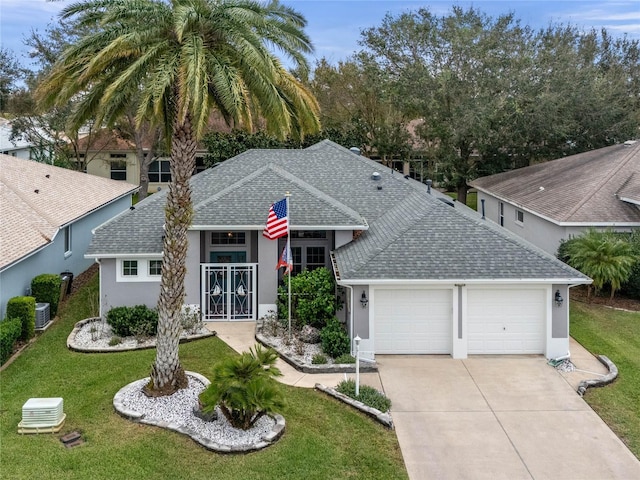 ranch-style home featuring stucco siding, driveway, central AC, an attached garage, and a shingled roof