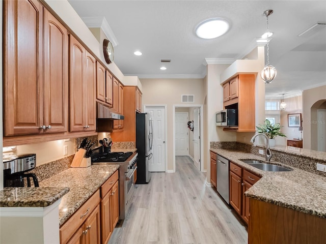 kitchen with visible vents, a sink, stone countertops, appliances with stainless steel finishes, and crown molding