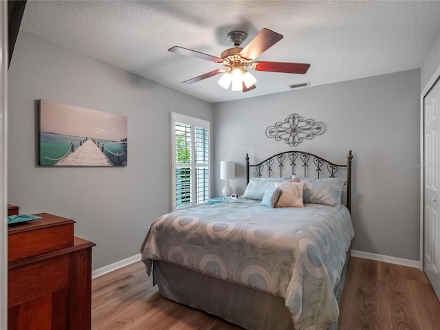 bedroom with visible vents, baseboards, and wood finished floors