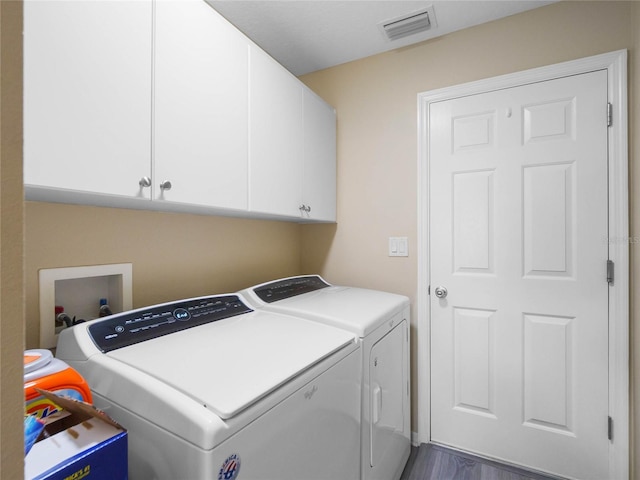 laundry area featuring cabinet space, wood finished floors, visible vents, and independent washer and dryer